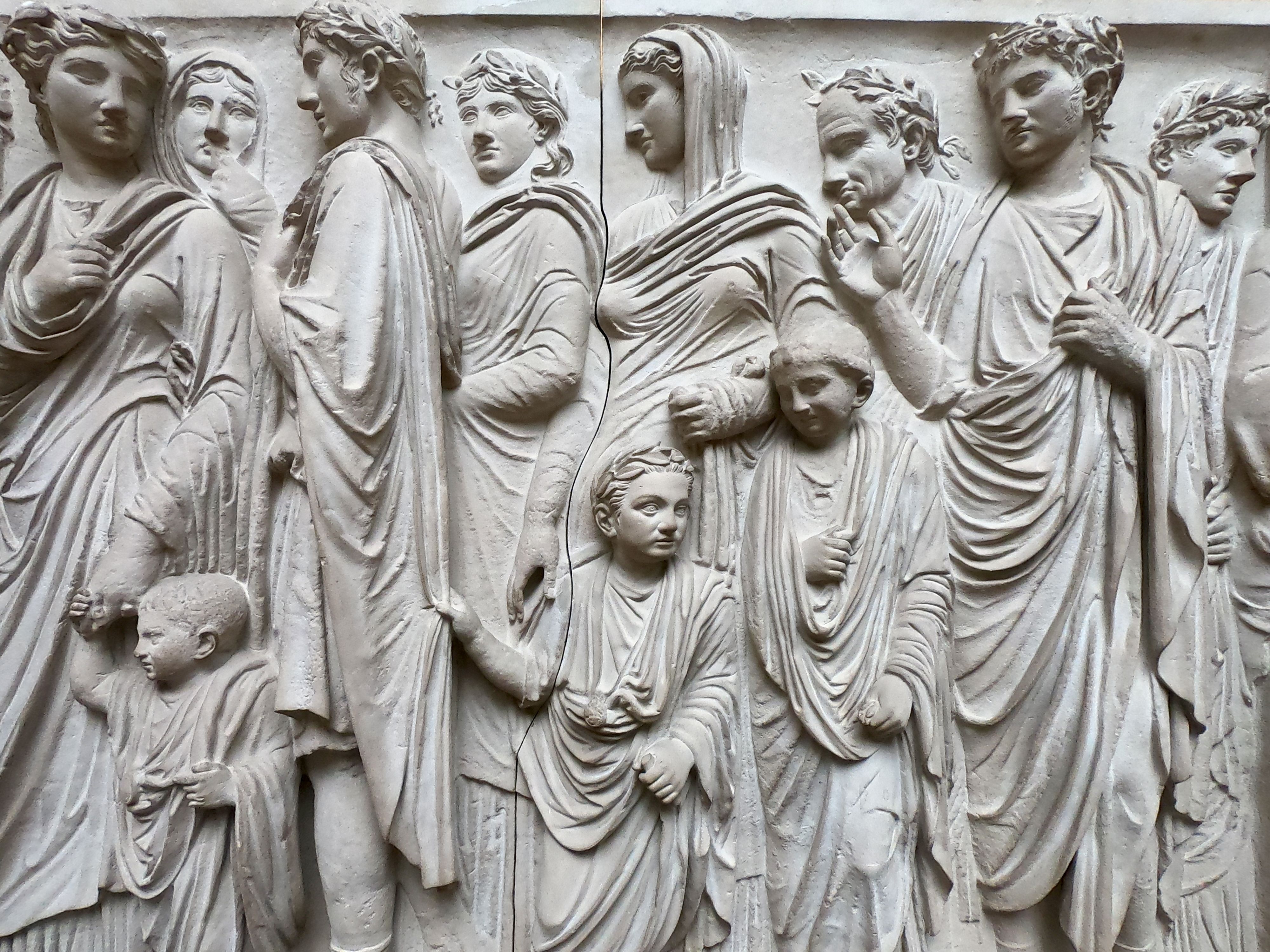 Intricate stone carving depicting ancient Roman figures in a museum setting