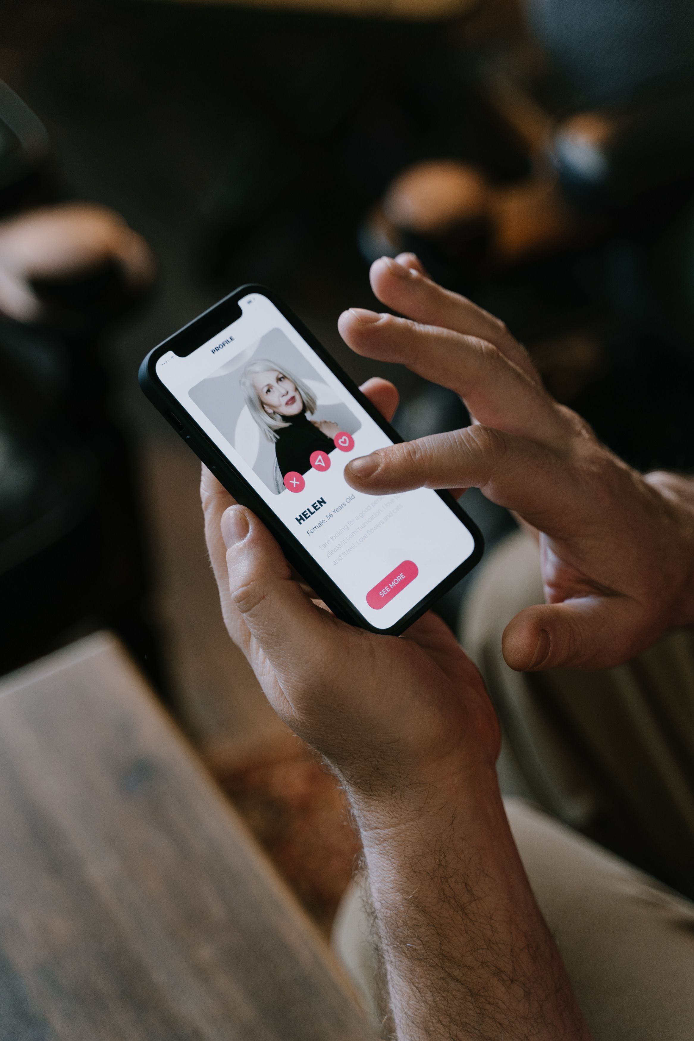 Close-up of hands using a modern dating app on a smartphone indoors