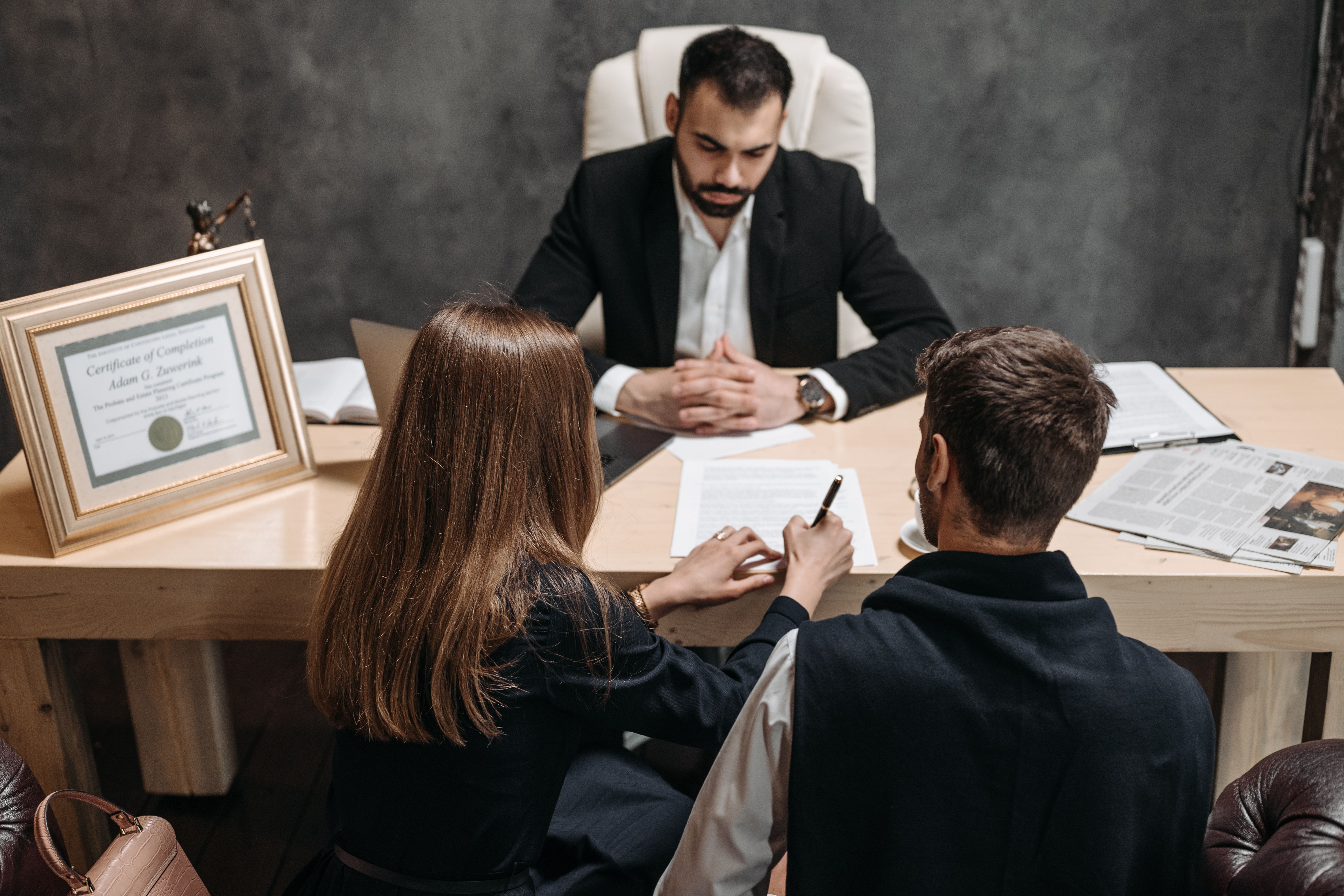 Lawyer discussing legal documents with clients during a civil lawsuit consultation.