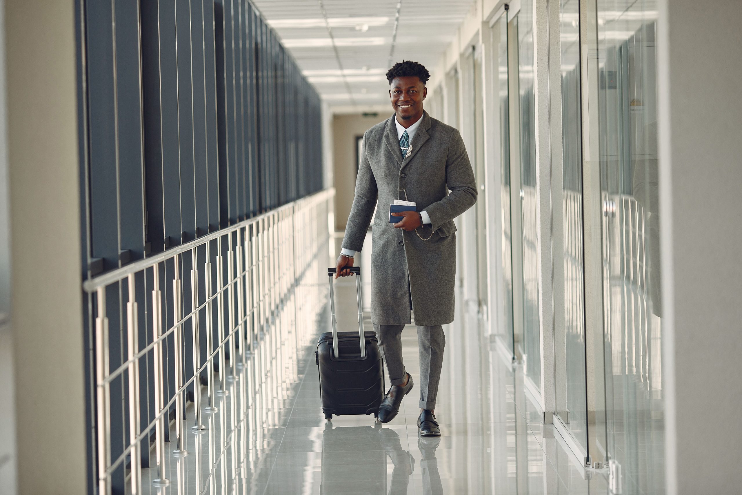 Traveler with suitcase and passport walking through a contemporary airport terminal